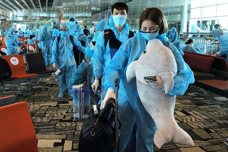 A Vietnamese woman carries a stuffed animal while boarding a repatriation flight from Singapore to Vietnam amid spread of the coronavirus outbreak at Changi airport, Singapore. REUTERS/Mai Nguyen    